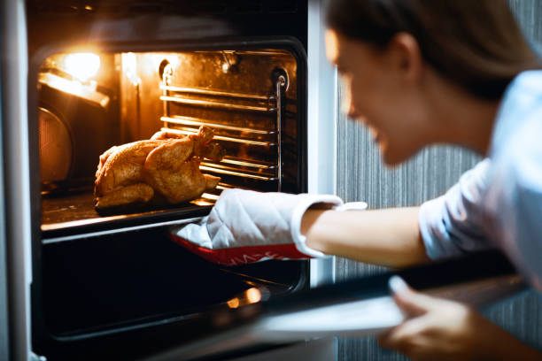 istock Housewife preparing roasted chicken in oven at kitchen 2176399986