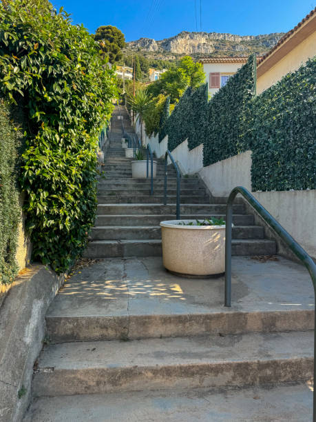 Golden light shining through the rooftops onto stone steps leading to the beach