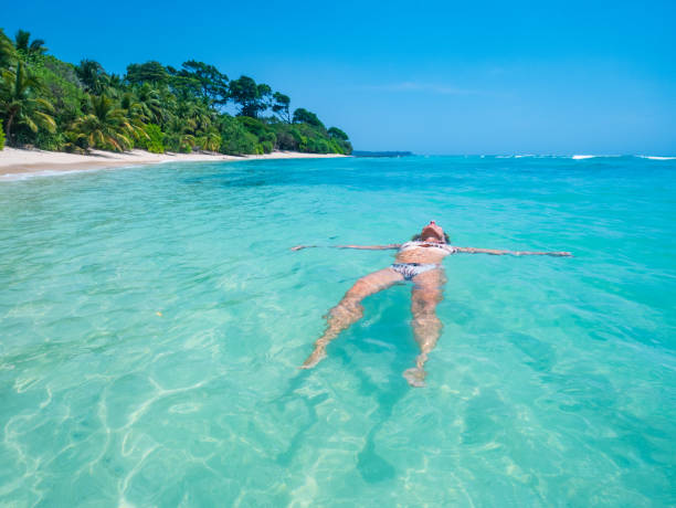 istock Serene tropical getaway woman relaxing in clear blue waters 2176403764