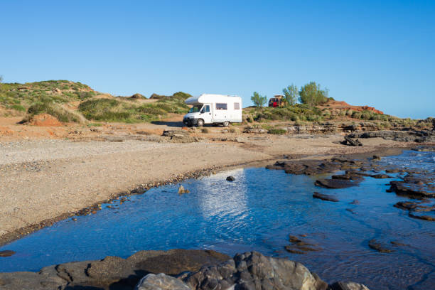 istock Serene seaside rv camping experience, Motorhome parked by a tranquil coastal inlet under a clear blue sky. Peloponnese, Greece. 2176403809