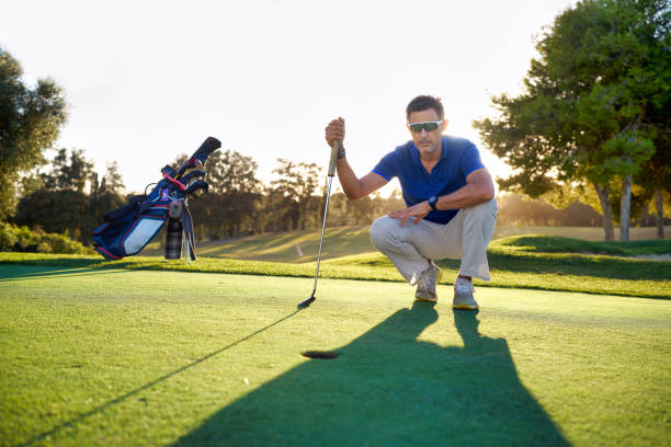 A golfer on the putting green analyzing his shot to the hole