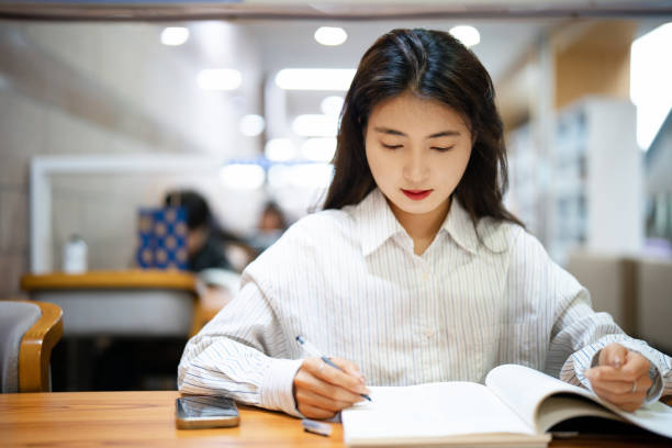 istock Adult female university student studying in public library 2176408670
