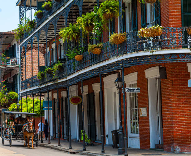 NOLA architecture, brick wall building with balconies and intricate ironwork columns in a street of the French Quarter, New Orleans, Louisiana