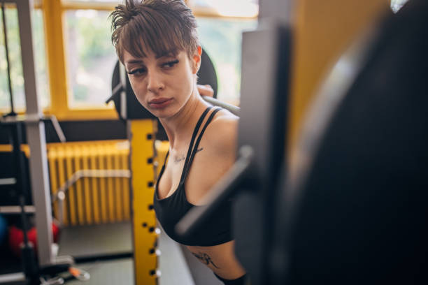 istock Young woman executing barbell squats in workout space 2176420088