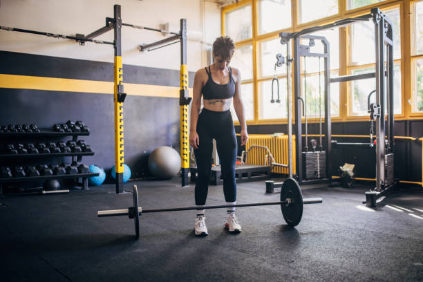 istock Woman preparing barbell workout in modern gym space. 2176422203