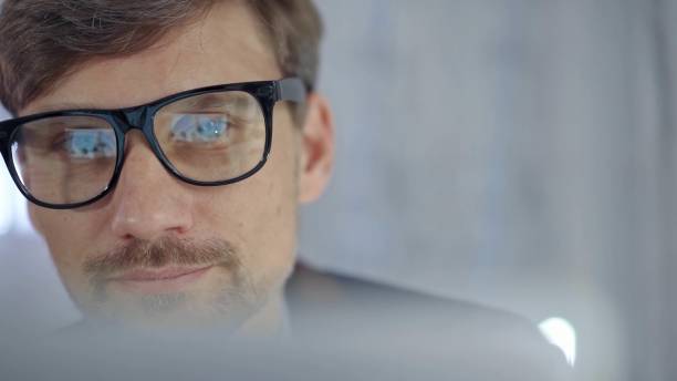 istock Businessman with glasses looking intently obscured partially by a translucent surface of laptop. Business people concept 2176423974