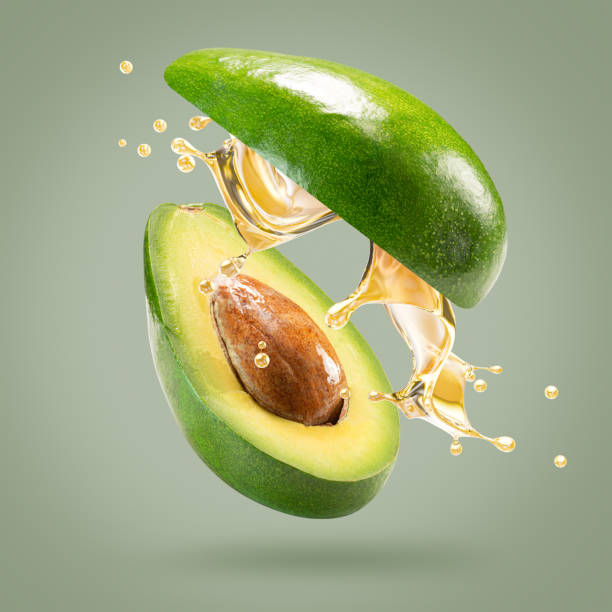istock avocado with oil splash on a light green background 2176429308
