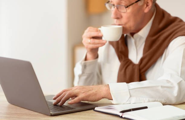 istock Senior Man At Laptop Drinking Coffee Working Sitting In Office 2176429452