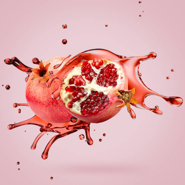 istock pomegranate with juice splash on a light pink background 2176430937