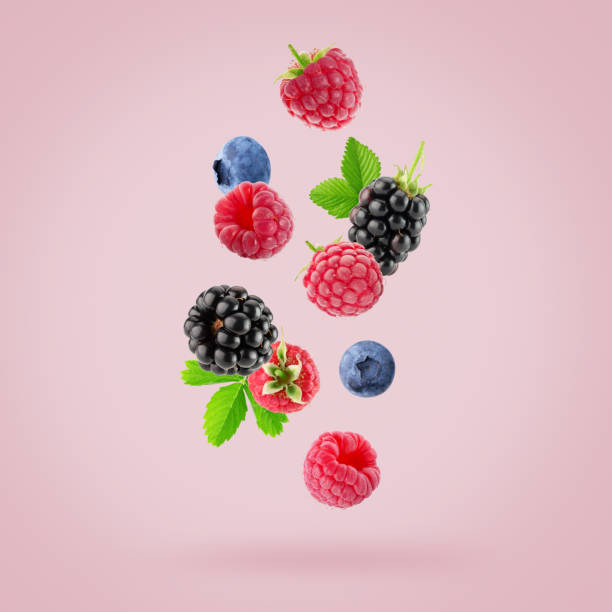 istock falling raspberries, blackberries and blueberries on a light pink background 2176430960