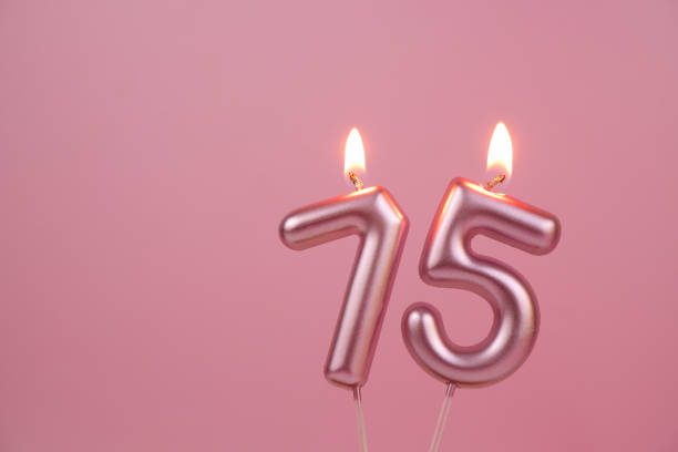istock Pink birthday candles  on pink background, number 75 2176431164