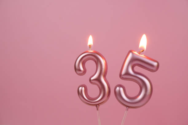 istock Pink birthday candles  on pink background, number 35 2176431239