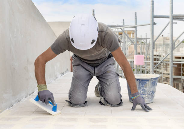 istock Craftsman in grey work clothes puts grout with a float sitting on his knees during construction 2176434068