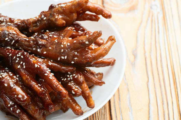 Caramelized korean or Chinese chicken foots ( paws ) with sesame . Top view photography