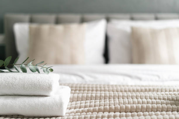 istock Neatly made bed with folded towels on top, copy space 2176436049