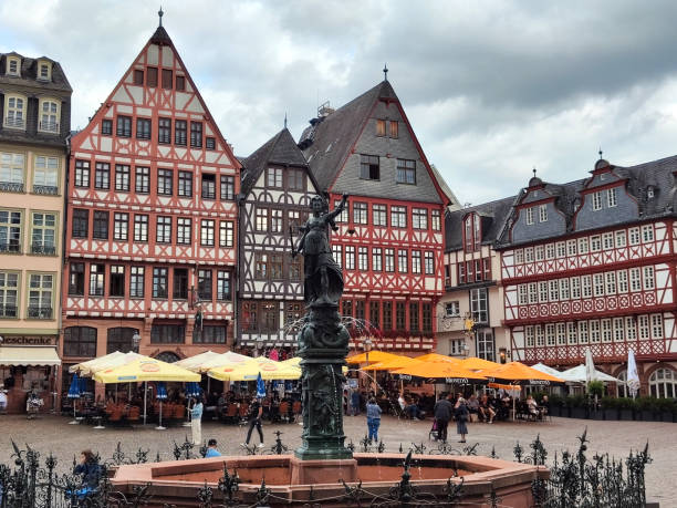 People walking at the Römerberg, in Frankfurt, Germany. The square is the historic heart of the medieval Altstadt (old town) and today a popular tourist destination.