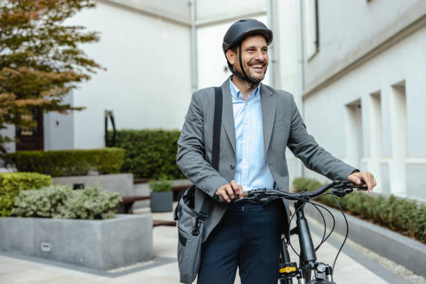 istock Smiling businessman commuting to work on bicycle in urban setting 2176439434