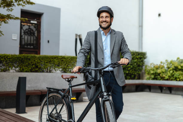 istock Smiling businessman commuting to work on bicycle in urban setting 2176440400