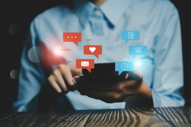 istock A person holding a smartphone with colorful notification icons on screen, representing digital communication and social interaction. 2176451023