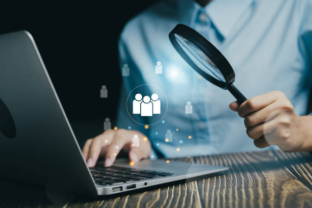 istock Person examining data with a magnifying glass, analyzing information on a laptop. 2176451565