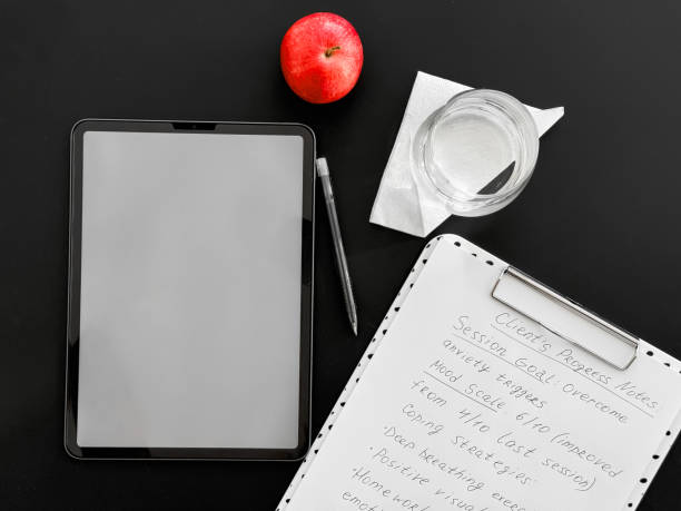 Blank black digital tablet on red paper background.