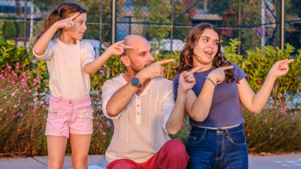 A family with boy and girl child posing on photo shooting, sitting close to a window
