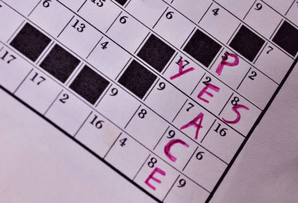 Close up of  crossword puzzle  with red pen showing  words YES PEACE  ,inspirational moment