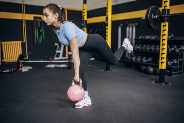 istock Focused woman lifting kettlebell on gym's floor. 2176460790