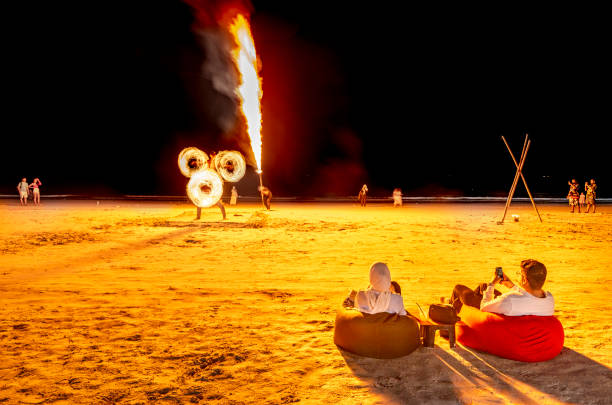 Langkawi Island,Malaysia-May 05 2023: In the evening,after sunset,talented fire artists perform impressive fire eating and flame breathing manoeuvres,in front of tourists seated on the sand.