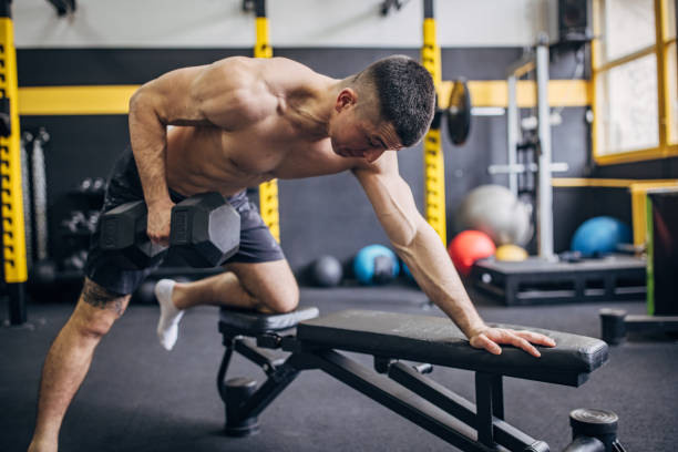 istock Focused man performing dumbbell row on workout bench 2176461887