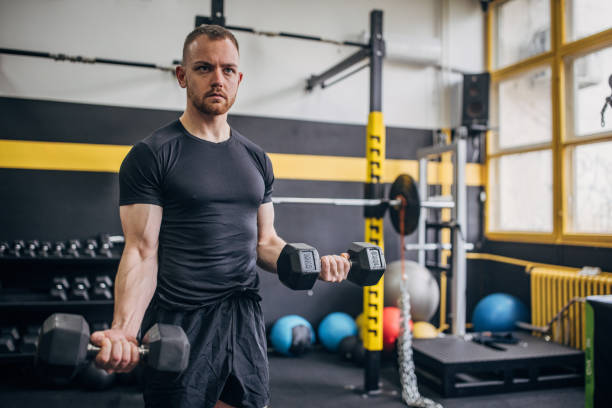istock Man exercising with dumbbells in modern gym 2176468395