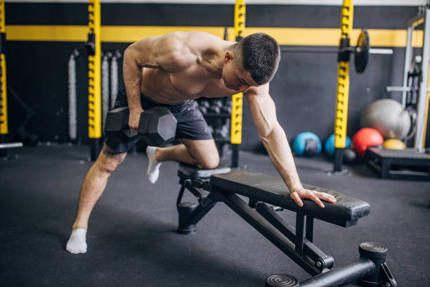 istock Man doing single-arm row with dumbbell in gym setting 2176469596