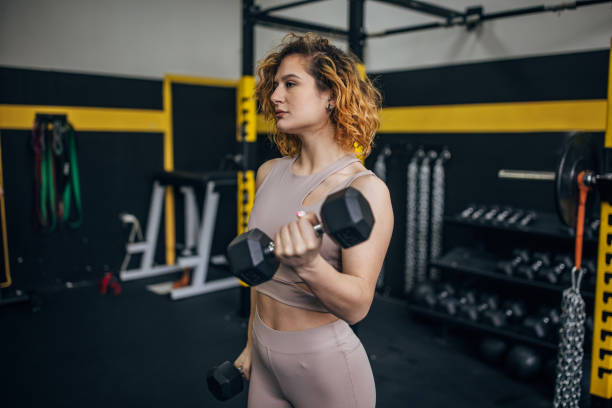 istock Strength-focused woman lifting dumbbell in gym 2176472241