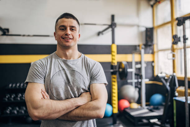 istock Smiling man in a gym leaning against workout equipment 2176472726