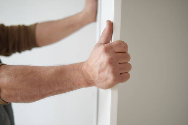 istock A man is currently holding a door frame while he is engaged in construction work activities 2176473509