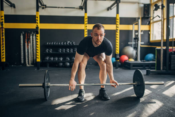 istock Man preparing to lift weights in a modern gym. 2176474923