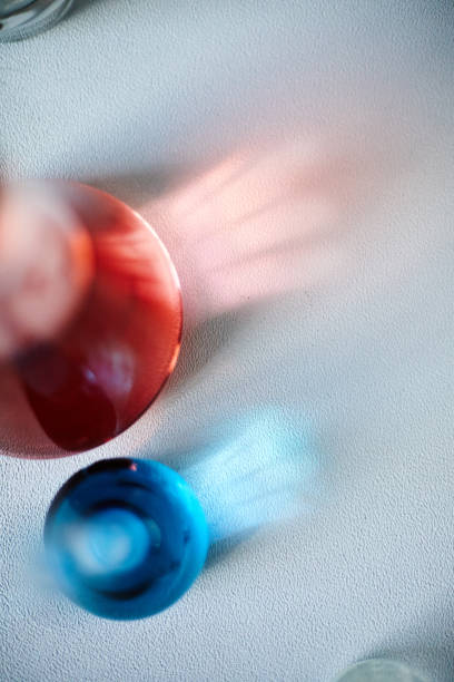 Top view of light reflection going through glass beakers filled with red and blue liquids placed on laboratory table, copy space