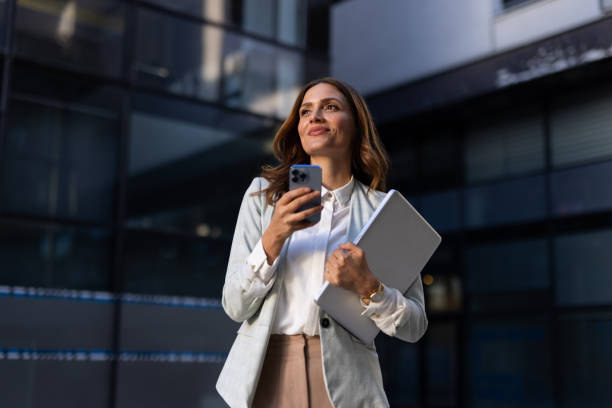 Stylish businesswoman using her phone while navigating the city
