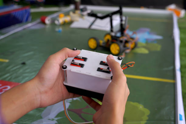 Asian high school students practice moving robots on the playing field To perform missions according to the rules of the robot competition. Soft and selective focus.