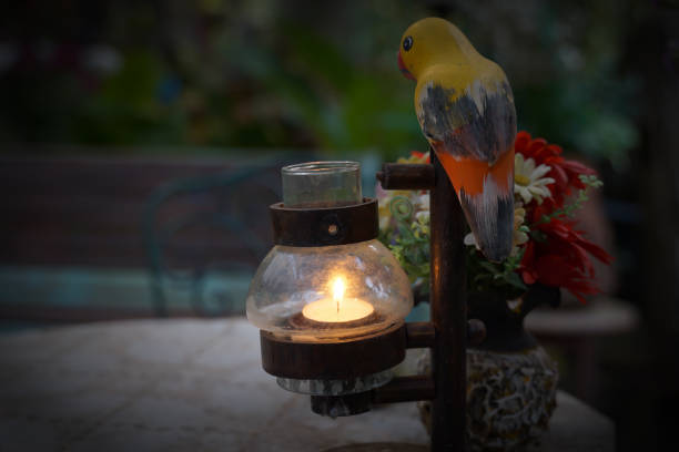 Wooden candlestick covered in glass, lantern shape, decorated with ceramic parrots. For using candles to decorate the place beautifully. look romantic at night.