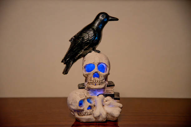 istock Halloween decoration with a skull and blue eyes on a brown lacquered table top in a bright room 2176478089