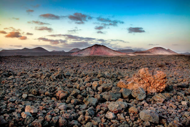 A volcanic landscape with mountains and a dramatic sky in Lanzarote in the Timanfaya National Park