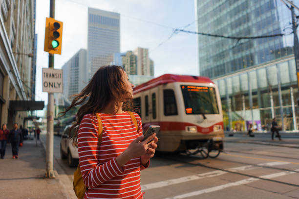 istock Woman using smartphone waiting for the tramway in downtown 2176483370