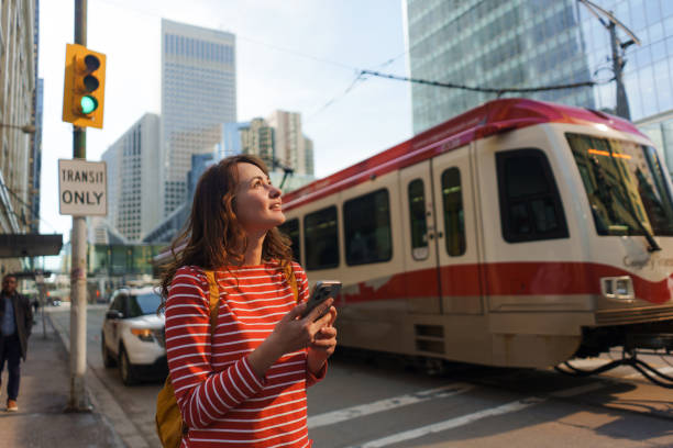 istock Woman using smartphone waiting for the tramway in downtown 2176483430