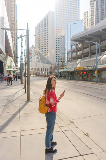 istock Woman using smartphone waiting for the tramway in downtown 2176483548