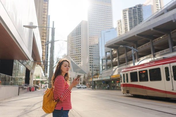 Woman using smartphone waiting for the tramway in downtown
