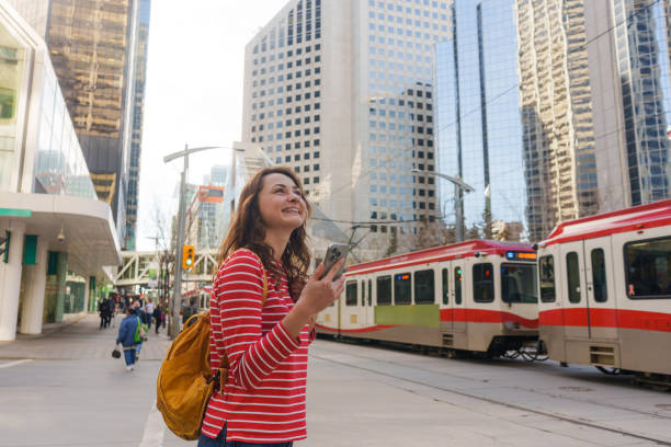 istock Woman using smartphone waiting for the tramway in downtown 2176483900