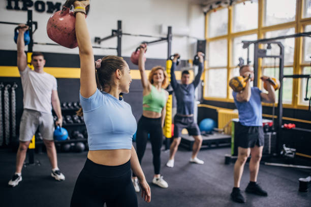 istock Diverse fitness group lifting kettlebells in unison. 2176485763