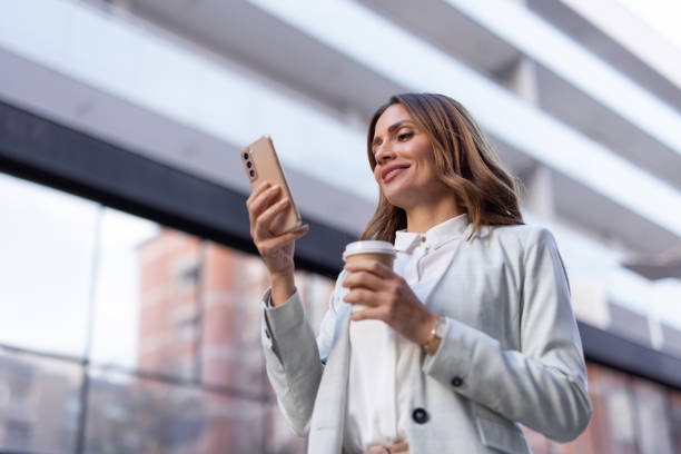 istock Stylish businesswoman using her phone while navigating the city 2176486063