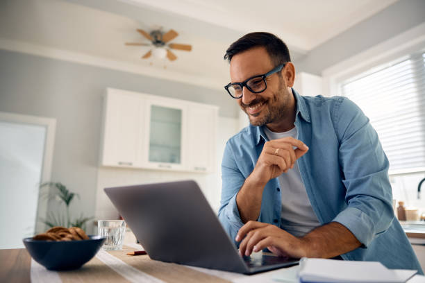 istock Happy man surfing the net on laptop at home. 2176488377